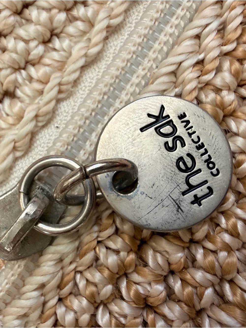 The Sak Silver Round Logo Tag on Cream Braided Accent